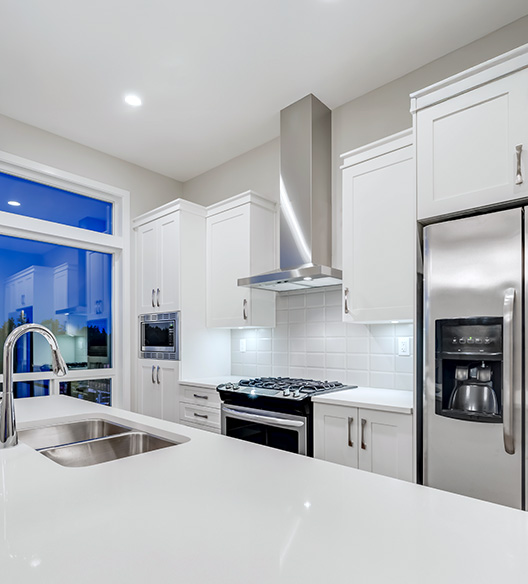 A modern kitchen with white shaker cabinets and stainless steel appliances